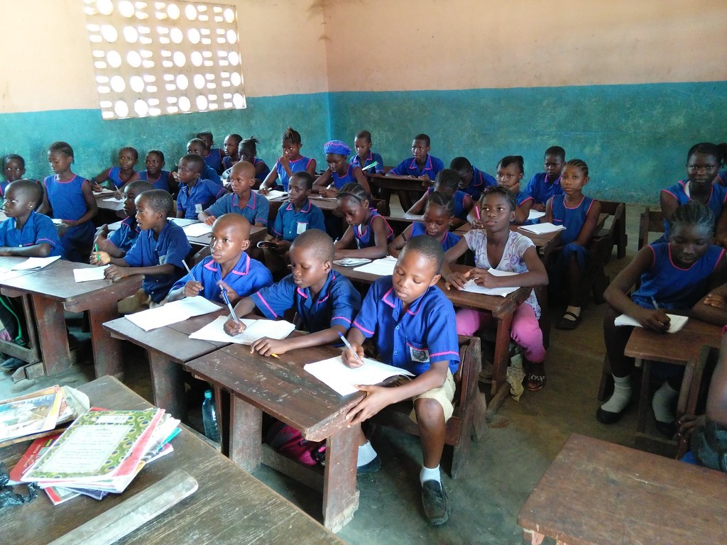 (c) Develop Africa. Empowerment begins with education and respect, taught early. Male and female students in a classroom in Sierra Leone