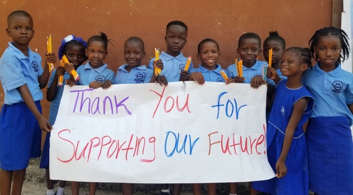 (c) Develop Africa. Pupils holding a banner thanking Develop Africa fof supporting their future.