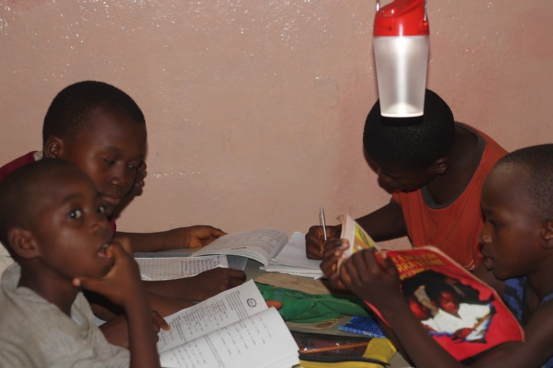 (c) Develop Africa. Students studying with solar lamps provided by Develop Africa.