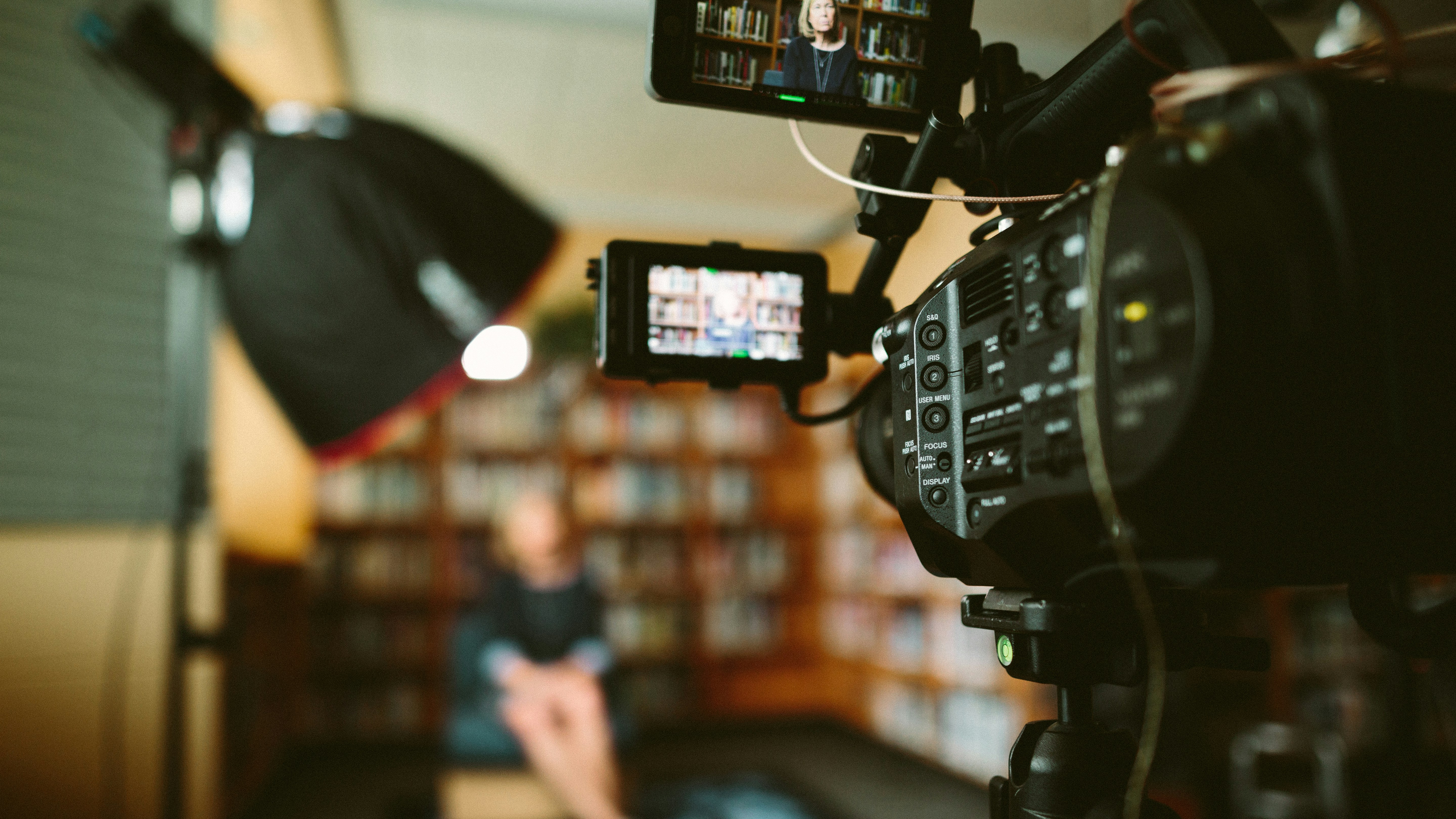 recording a person sitting in front of a bookshelf