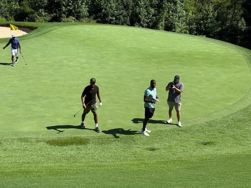 Mo Sanu and other golfers playing golf on the pitch at Swing FORE Change 2026