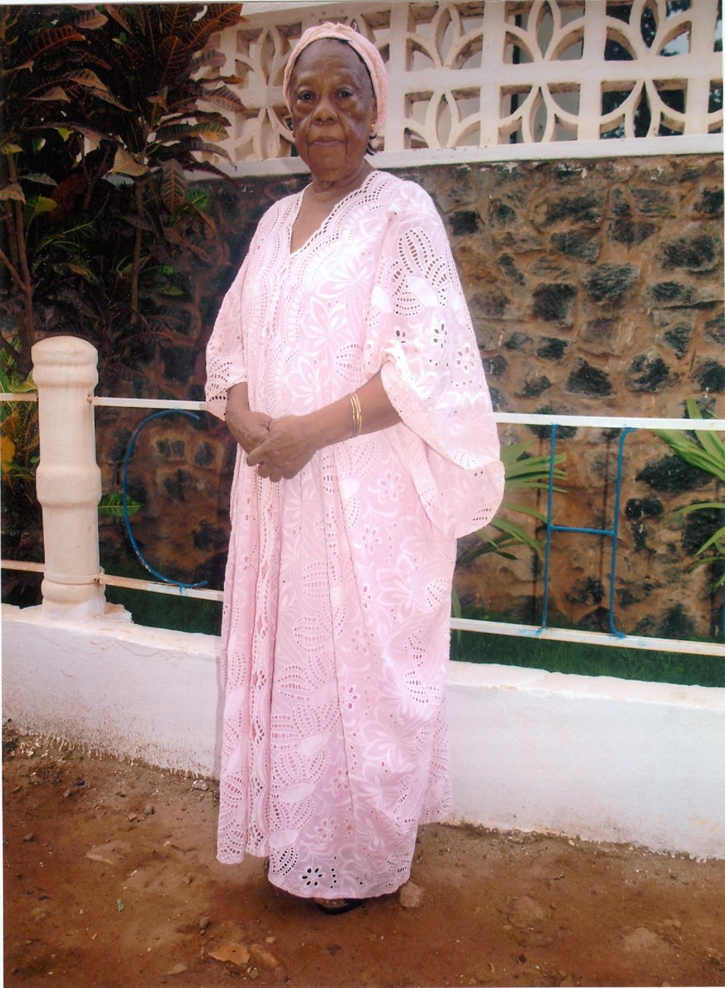 Zainabu Renner in a pink embroidered gown, standing outdoors