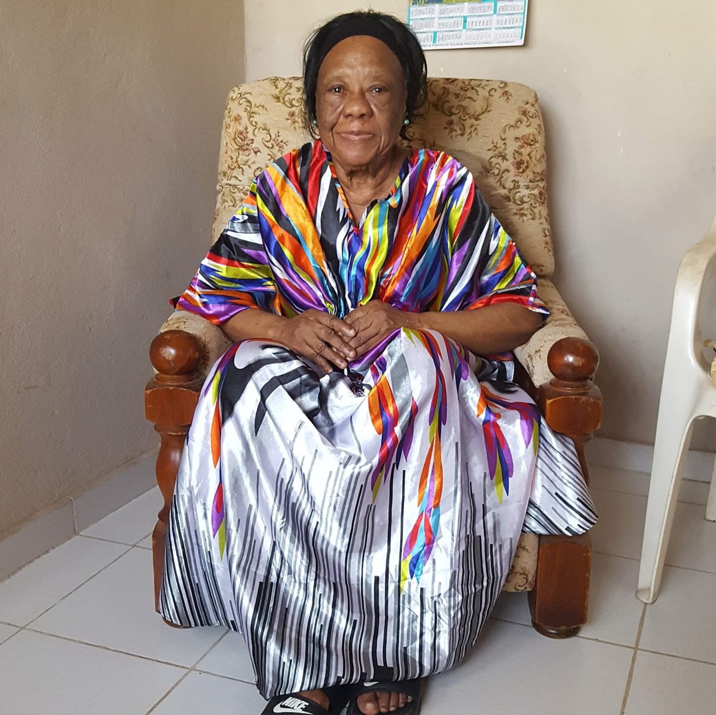 Zainabu Renner seated at home in a colorful gown
